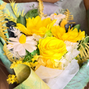 Bouquet of yellow flowers with green leaves on a marble surface
